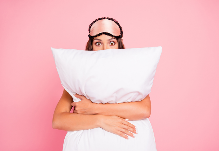 Woman Holding Pillow Against Pink